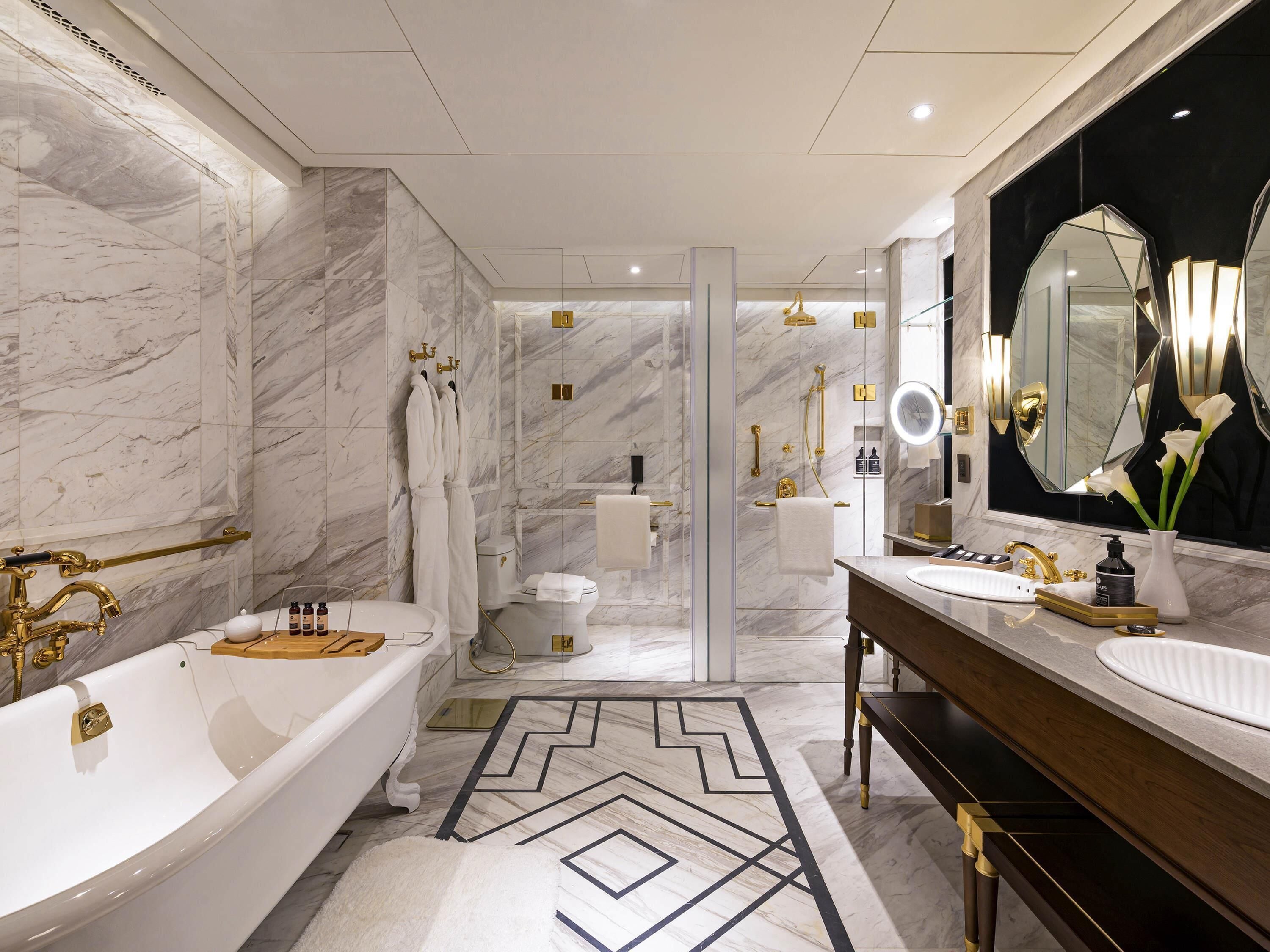 Un baño moderno con bañera, dos lavamanos, un espejo grande y zona de ducha.