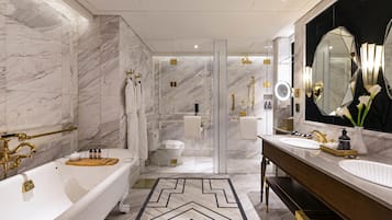 Un baño moderno con bañera, dos lavamanos, un espejo grande y zona de ducha.