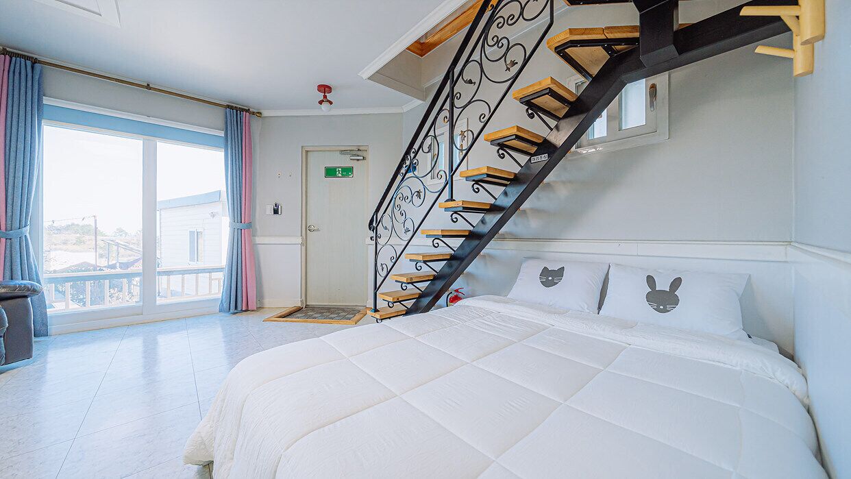 Una camera da letto con un letto, una scala e un balcone.