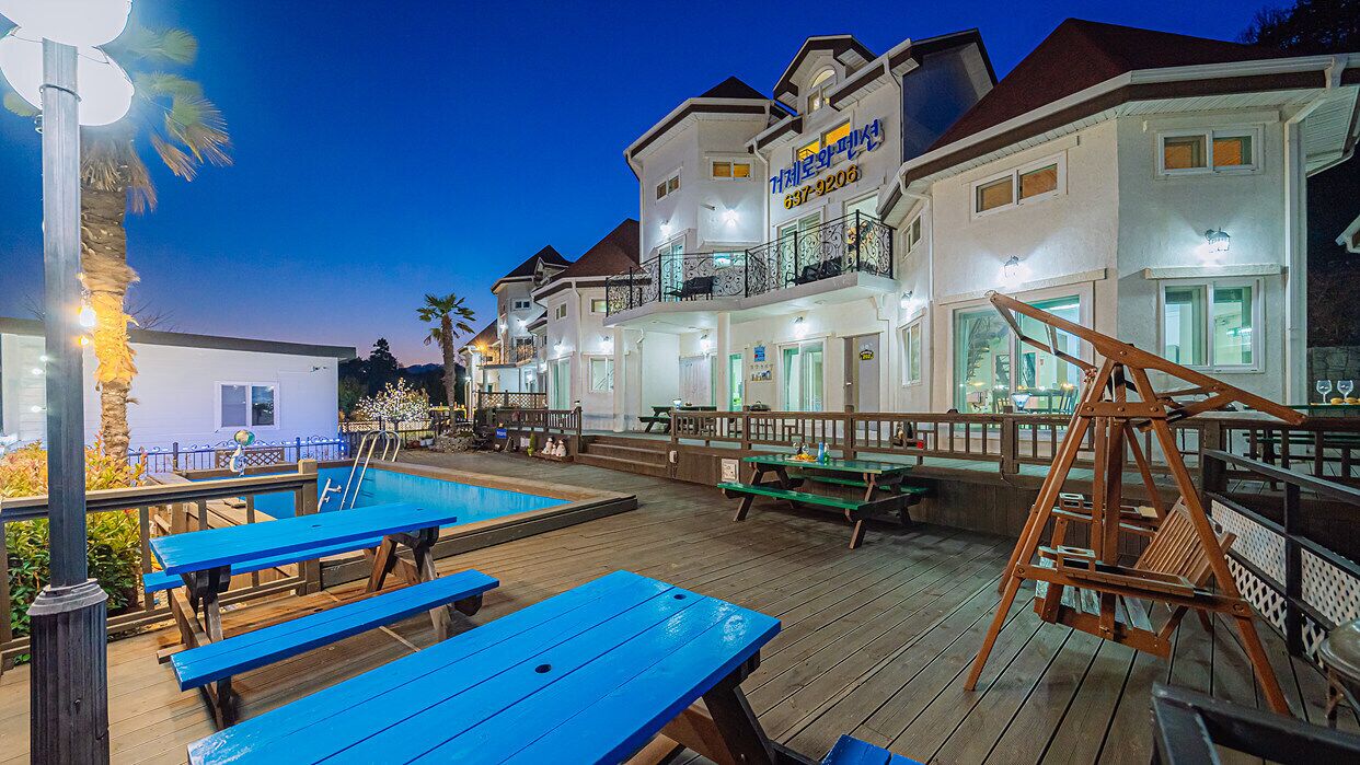 A waterfront hotel with outdoor seating and a pool.