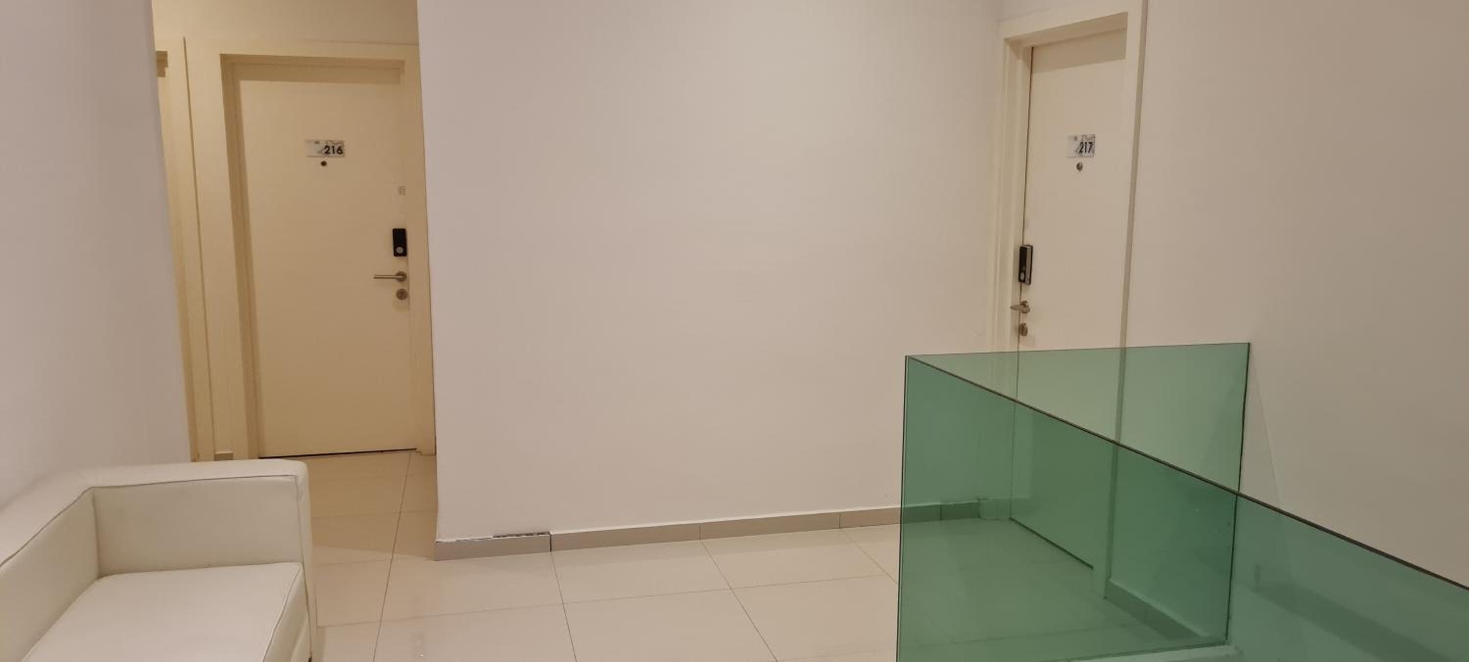 A hallway with two doors, one marked 216 and the other 217, and a glass partition.