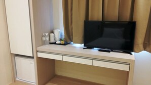 A hotel room with a flat-screen TV on a desk, a mini-fridge, and a small cabinet. - Star Tree Homestay (Kuantan)