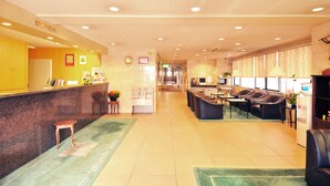 A reception area with a counter, seating, and a reception desk. - Matsumoto Tourist Hotel (Matsumoto)