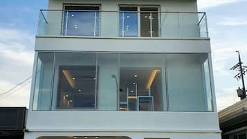 A two-story building with a glass facade, a sign reading "Mr. Flow Penston," and a visible entrance with a chandelier.