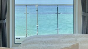 A hotel room with a large window offering a view of the ocean. - Mr. Slow (Sokcho)