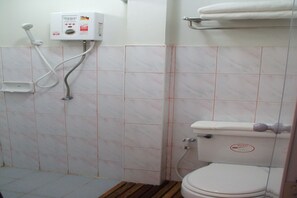 A bathroom with a toilet, a shower, and a control panel.