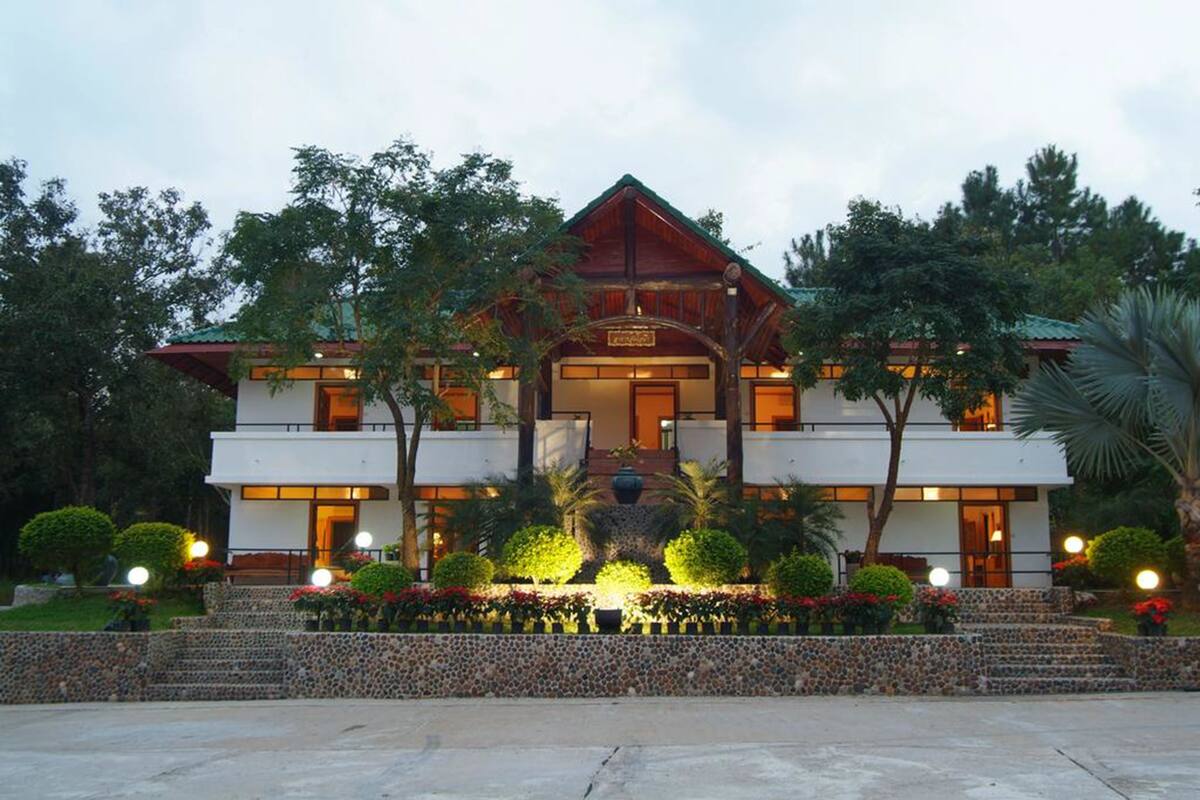 A two-story building with a symmetrical facade, a central entrance, and a stone staircase leading to the entrance.