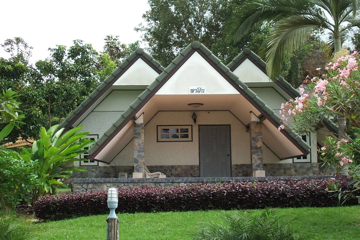 A building with a triangular roof and a sign above the door.