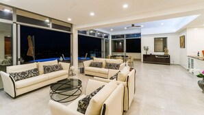 A modern living room with a sofa set, a coffee table, and a dining area with a table and chairs.