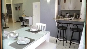 A compact kitchen with a dining area, including a table set with plates and a fan. - The McFarlane's Place is right in the heart of Ocho Rios Jamaica. (Ocho Rios)