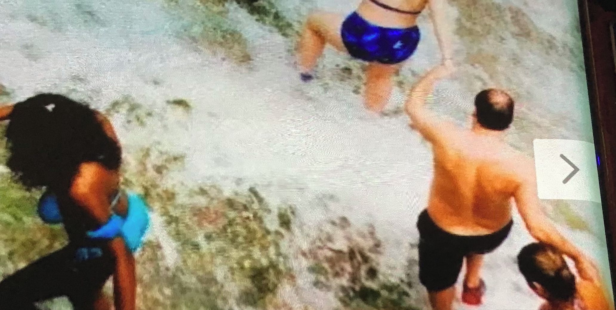 Ein Fernsehbild zeigt eine Strandansicht mit Personen.