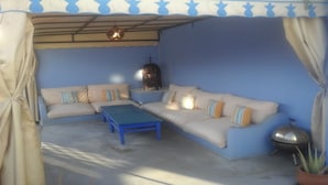 A cozy living area with a sofa set, a blue coffee table, and a decorative lamp. - A Luminous and Spacious Medina House with a Rooftop Chillout Terrace  (Asilah)