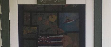 Ein gerahmtes Bildkunstwerk, das verschiedene Kunstwerke und Fotografien zeigt, darunter eine Flagge, ein Schiff und eine Landschaft.