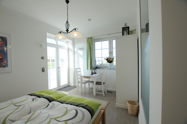 A modern hotel room with a bed, a desk, and a chair.