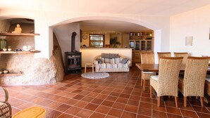 Ein gemütliches Wohnzimmer mit Kamin, einer Couch und Korbsesseln.