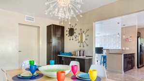 A modern kitchen with dark wood cabinets, a central island, and a decorative wall clock. - Fantastic Views and Reviews! Bright, Relaxing Oasis! (Palm Springs)