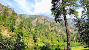 A hot tub on a deck with a view of a mountainous landscape. - New Remodel! Waterfront, pets, Outdoor Ent, Hottub & Views 4min to Leavenworth. (Leavenworth)