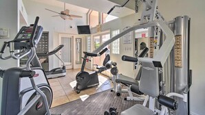 Ett gym med konditionsmaskiner, styrketräningsutrustning och ett löpband.