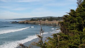 A coastal landscape with a rocky shoreline, waves, and a forested area. - Dog-Friendly, Secluded Redwoods Getaway With Private Hot Tub (Sea Ranch)