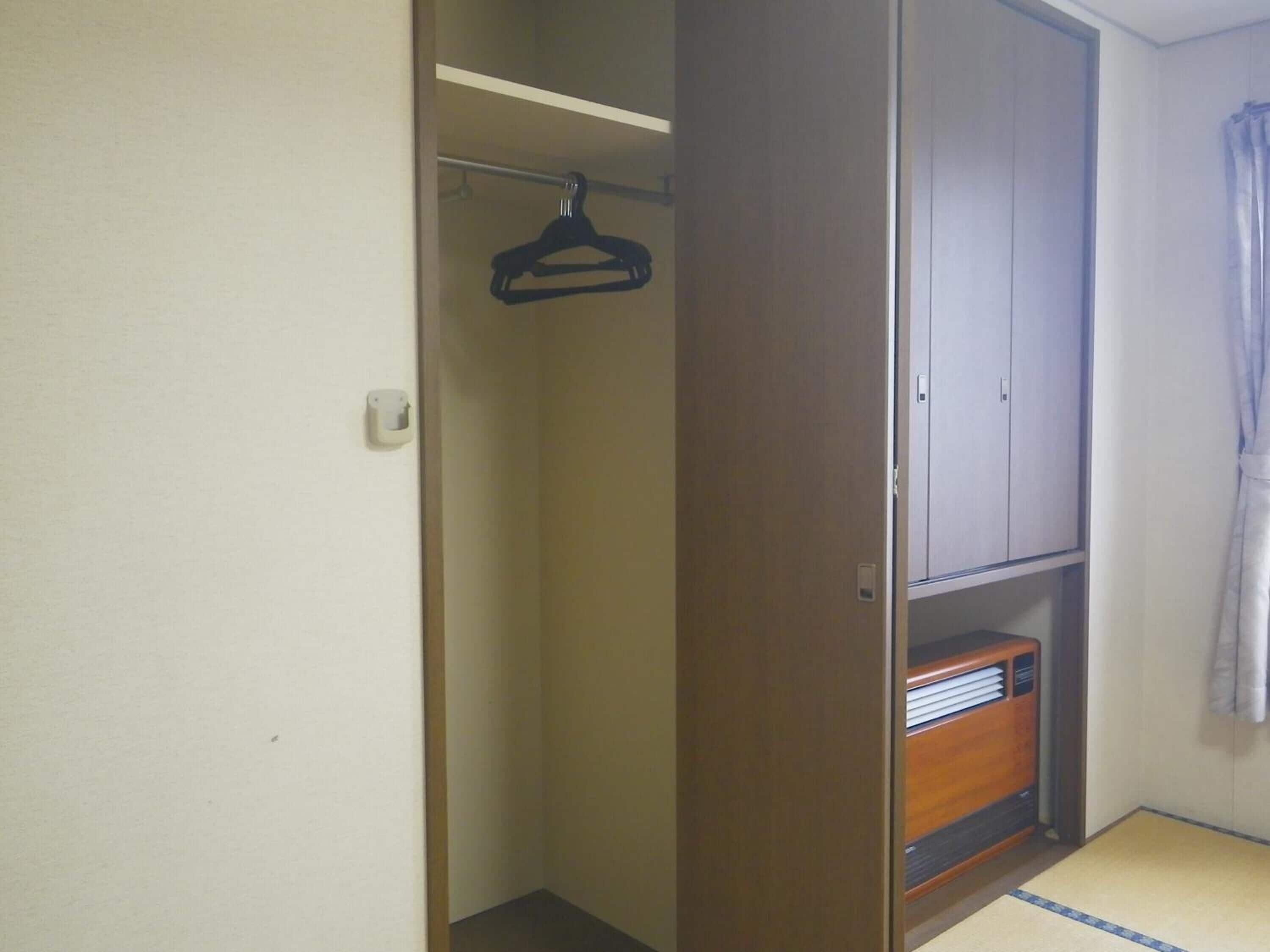 Une chambre équipée d’une armoire, d’un portant et d’un radiateur.