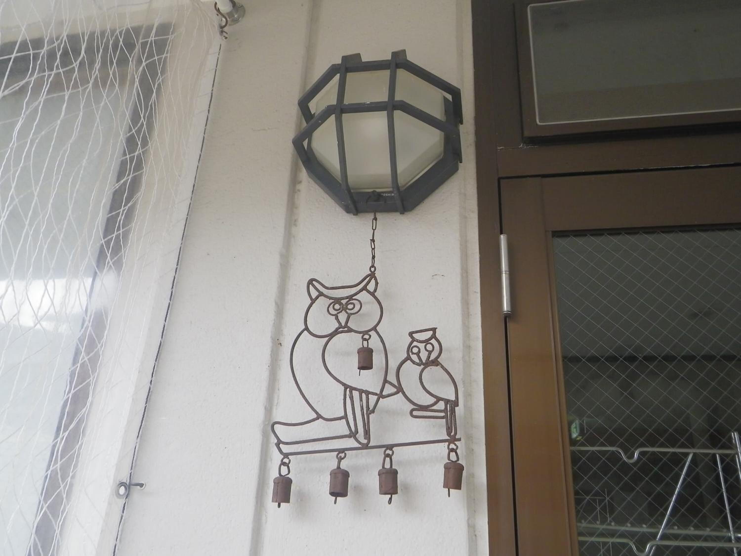 A wall-mounted decorative piece with an owl and a lantern.