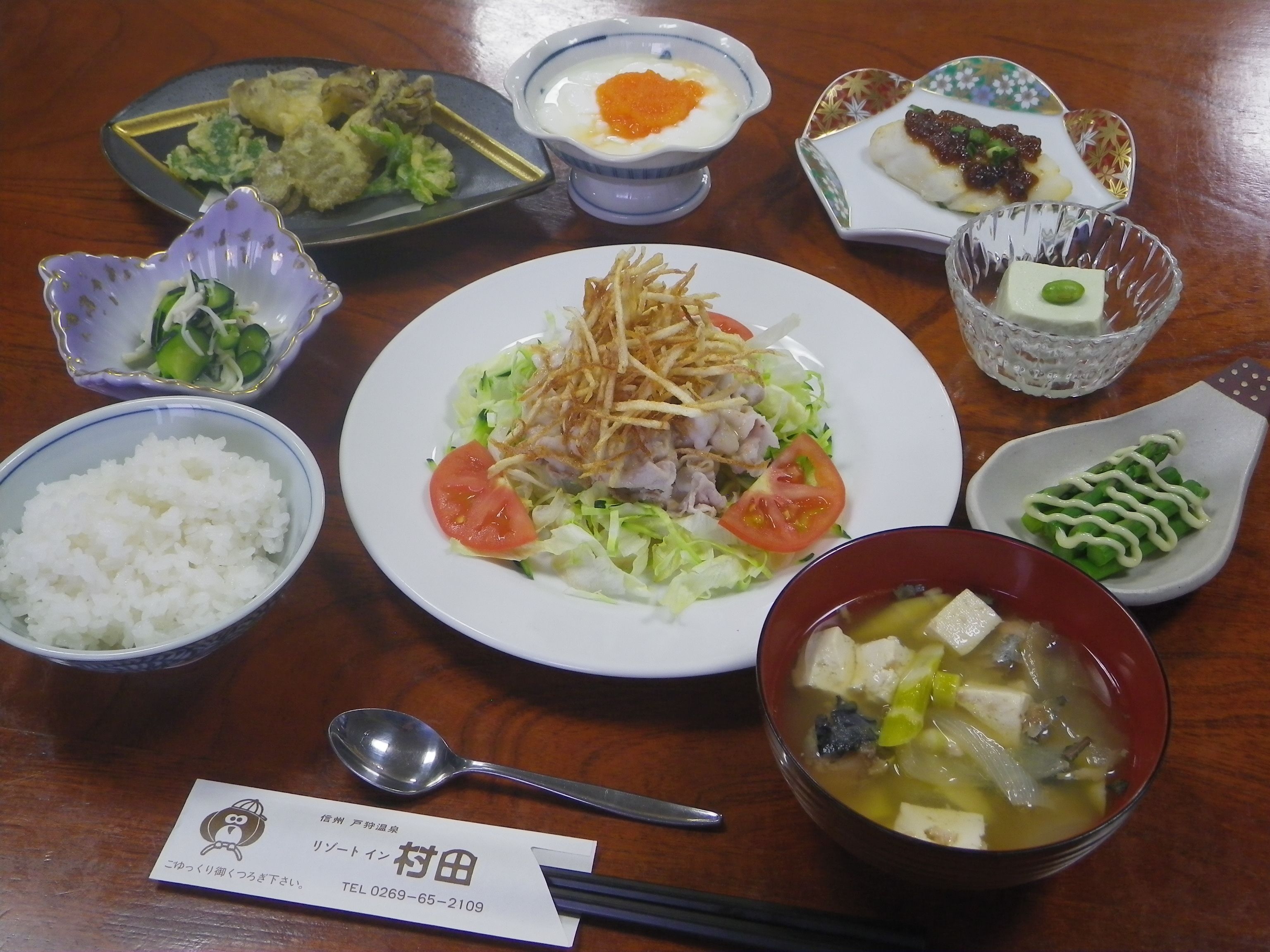 A variety of dishes including rice, soup, and a plate with vegetables and meat.