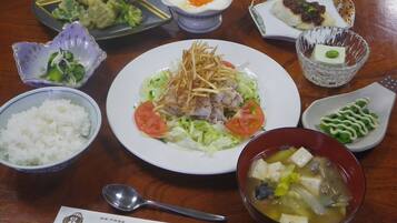 A variety of dishes including rice, soup, and a plate with vegetables and meat.