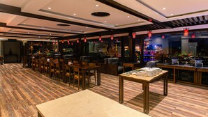 A restaurant with wooden flooring, tables, chairs, and red lanterns. - Aroma Tea House (Guilin)