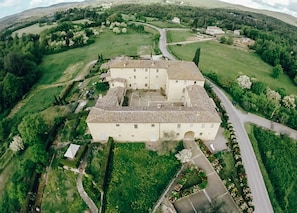 An aerial view of a large, rectangular building with a central courtyard, surrounded by lush greenery and a winding road. - La Senesina, Monteriggioni, Siena. In the best countryside of Tuscany ! (Siena)