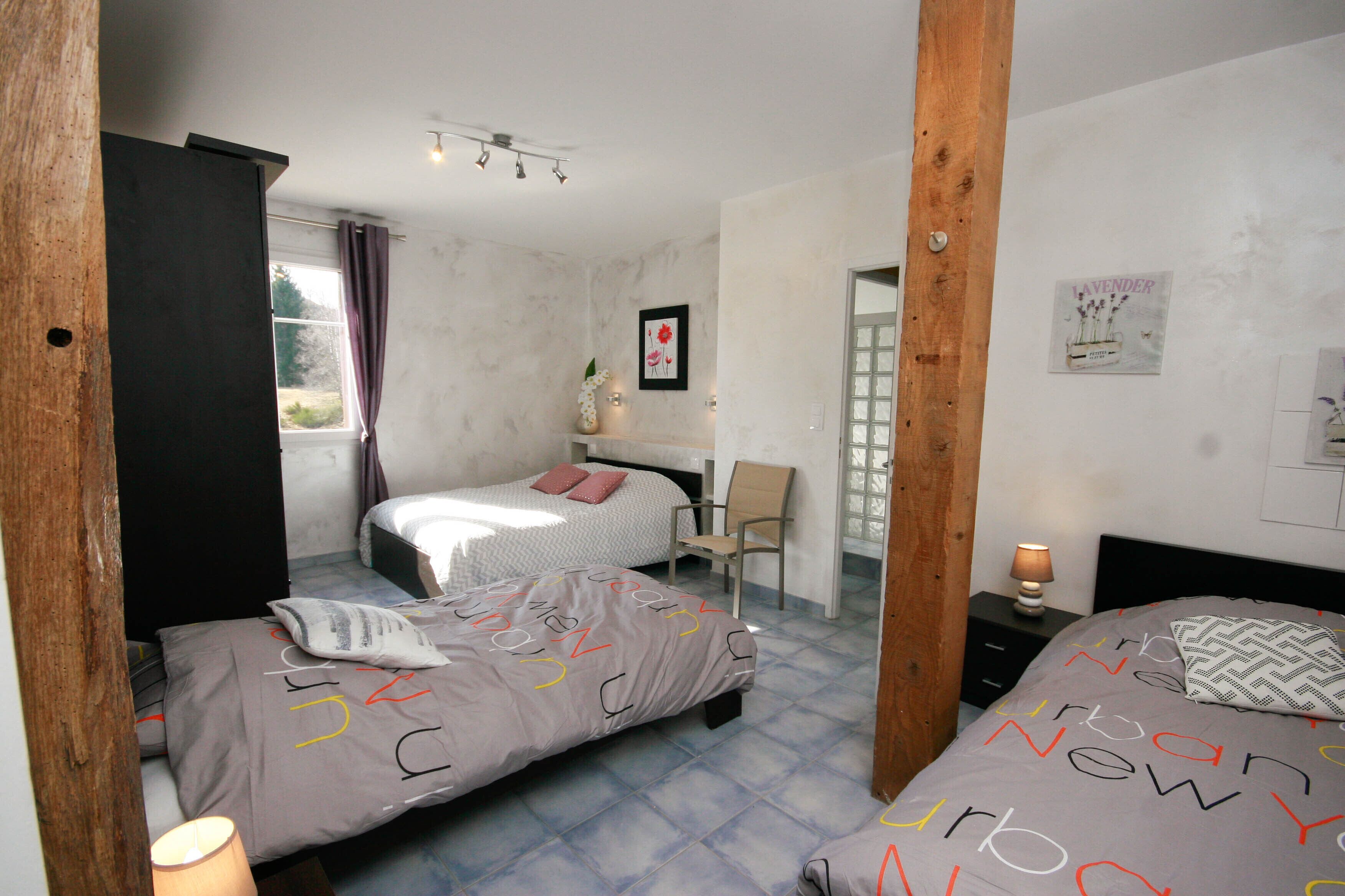 Une chambre avec deux lits, un bureau et une chaise.
