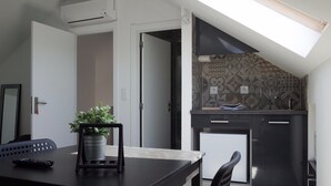 A modern kitchen with a skylight, a small refrigerator, and a potted plant on the counter. - Lisbon Beach Apartments 6. Studio, beach 5 minutes,  free wifi. (Costa da Caparica)