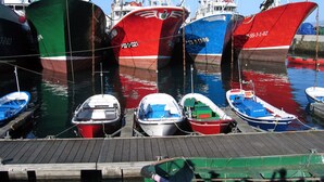 A marina with several boats docked, including a red and blue ship and smaller boats. - Quiet apartment in the geographical center of the Basque Country (Mendaro)