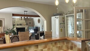 A kitchen with a wooden countertop, a built-in sink, and a hanging light fixture.