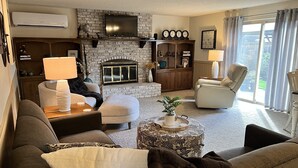 A living room with a fireplace, a television, and a comfortable seating area.