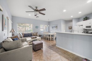 A modern living room with a sofa, coffee table, and dining area.