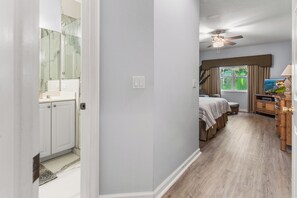 A hotel room with a bathroom, a bed, a desk, and a television. - PGA Village/Castle Pines Best Location Pet Friendly. (Port St. Lucie)