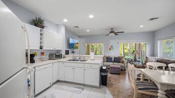Bright open-concept kitchen, dining and living area with updated flooring.