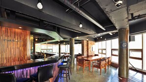 A bar area with wooden accents, a bar counter, and seating. - Aquarius resort (Geoje)