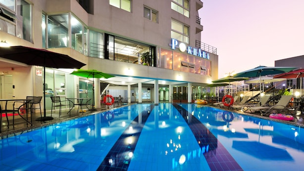 A hotel with a swimming pool, outdoor seating, and a sign reading "POKHARA". - Aquarius resort (Geoje)
