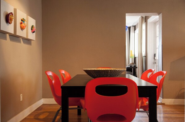 Een eetruimte met een zwarte tafel, rode stoelen en een decoratieve schaal op tafel.