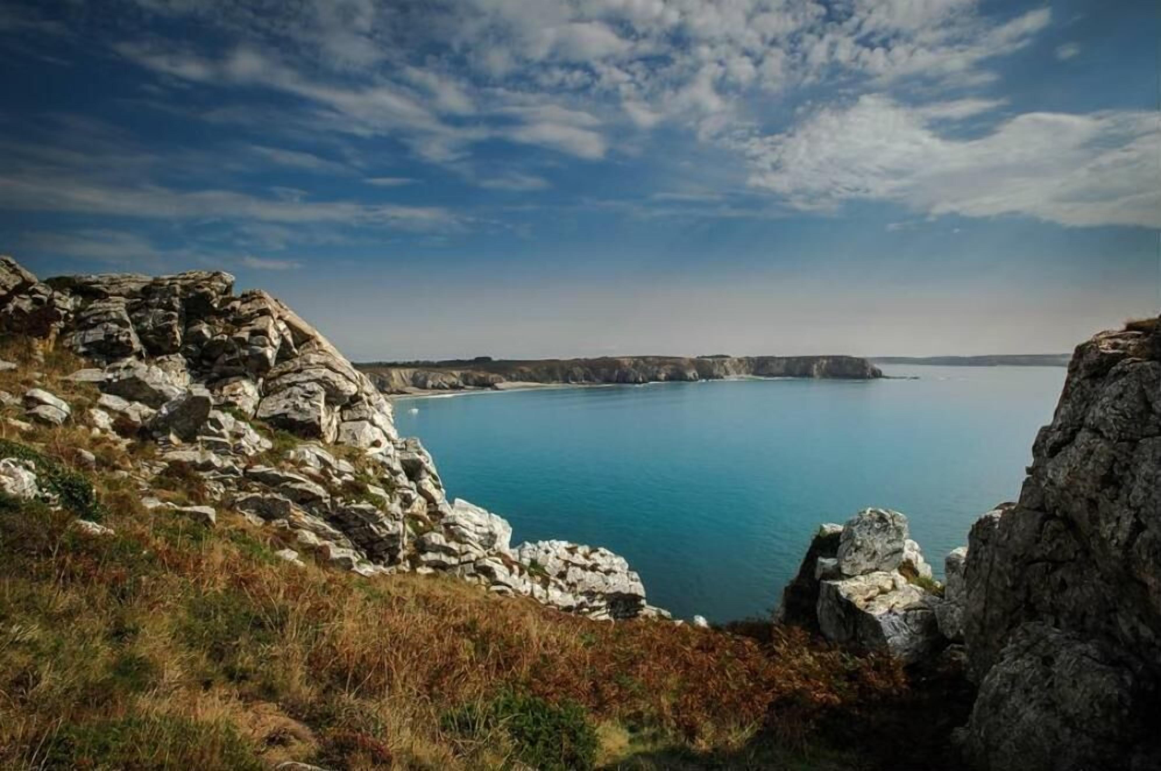 Un paisaje costero con acantilados rocosos y mar tranquilo.