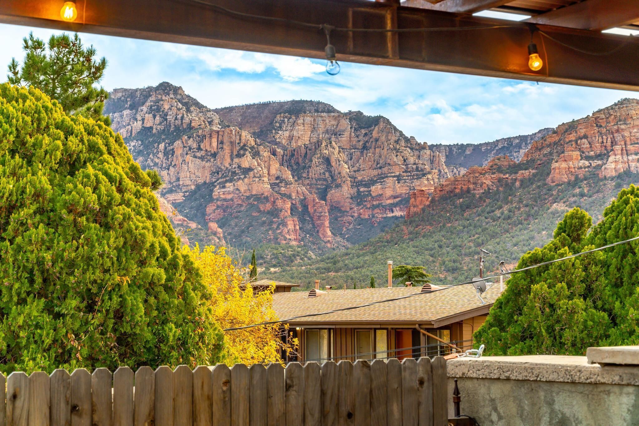 A view of a mountain range with a wooden fence in the foreground.