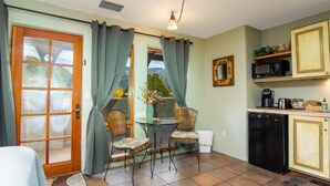 A compact kitchen with a dining area, featuring a small table, chairs, a refrigerator, and a microwave. - Walk a Block to Uptown to the main shops, tours, restaurants. (Sedona)
