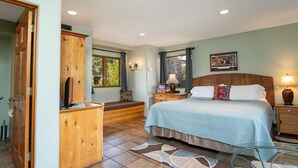 A bedroom with a bed, bedside tables, a wooden desk, and a window with curtains. - Walk a Block to Uptown to the main shops, tours, restaurants. (Sedona)