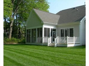Enjoy a peaceful retreat on this single-story house's covered porch, surrounded by a well-maintained lawn.