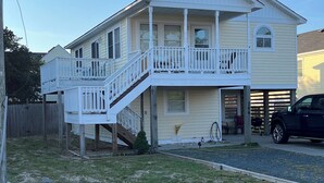 A two-story house with a front porch, a satellite dish, and a garage. - Don't Miss Out on the 'Sunshine'; Unwind, Relax, Put Your Feet Up and enjoy! (Kill Devil Hills)