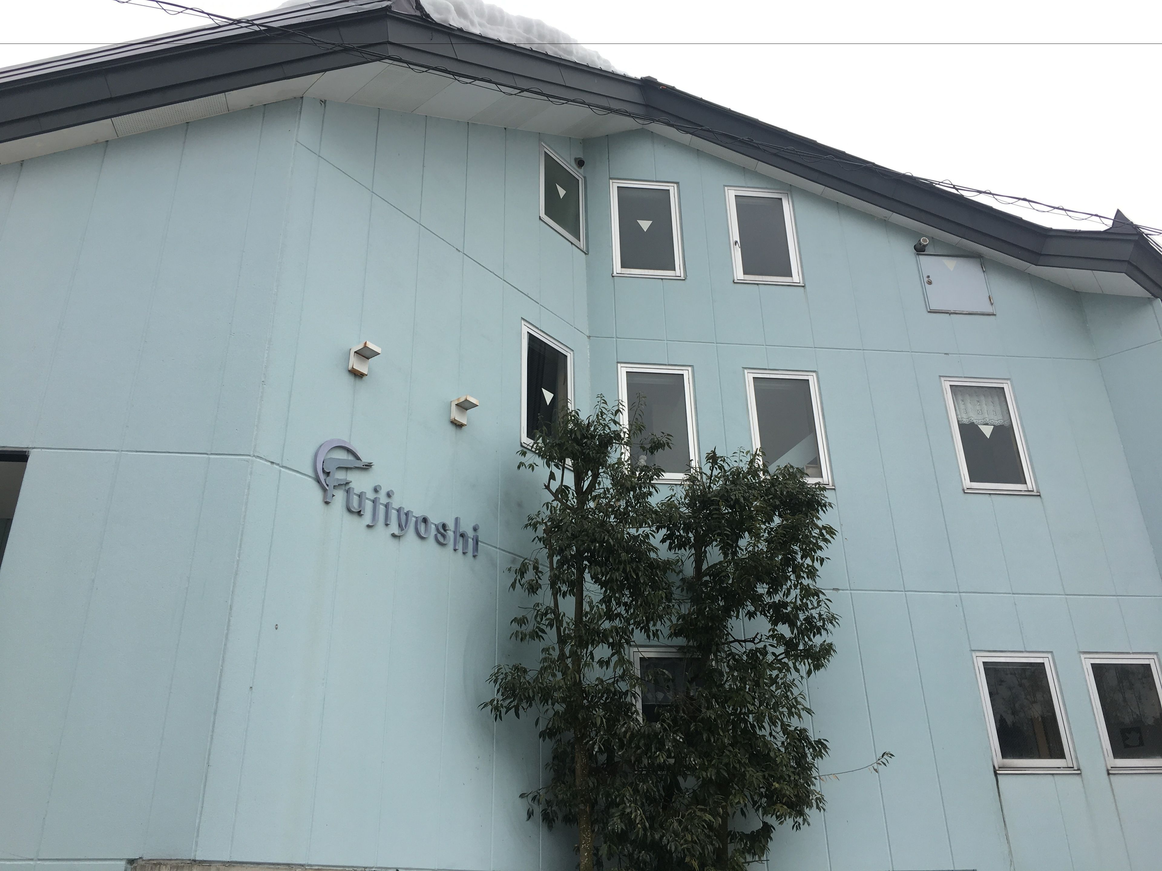 A light blue building with the name 'Fujiyoshi' on the side.