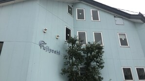 A light blue building with the name 'Fujiyoshi' on the side. - Fujiyoshi (Nozawaonsen)