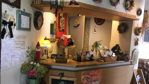 A reception desk with a map, a lamp, and various decorative items. - Fujiyoshi (Nozawaonsen)