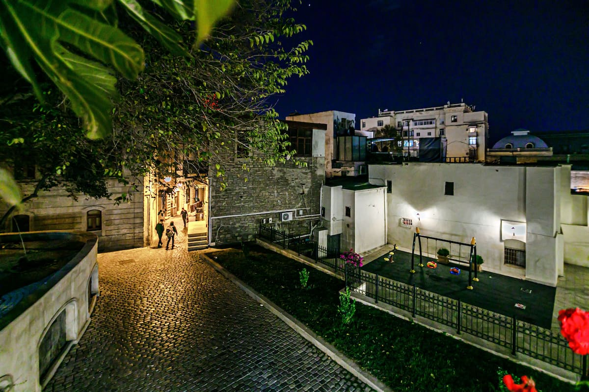 Una calle adoquinada que lleva a un edificio con fachada de piedra y una pequeña entrada.